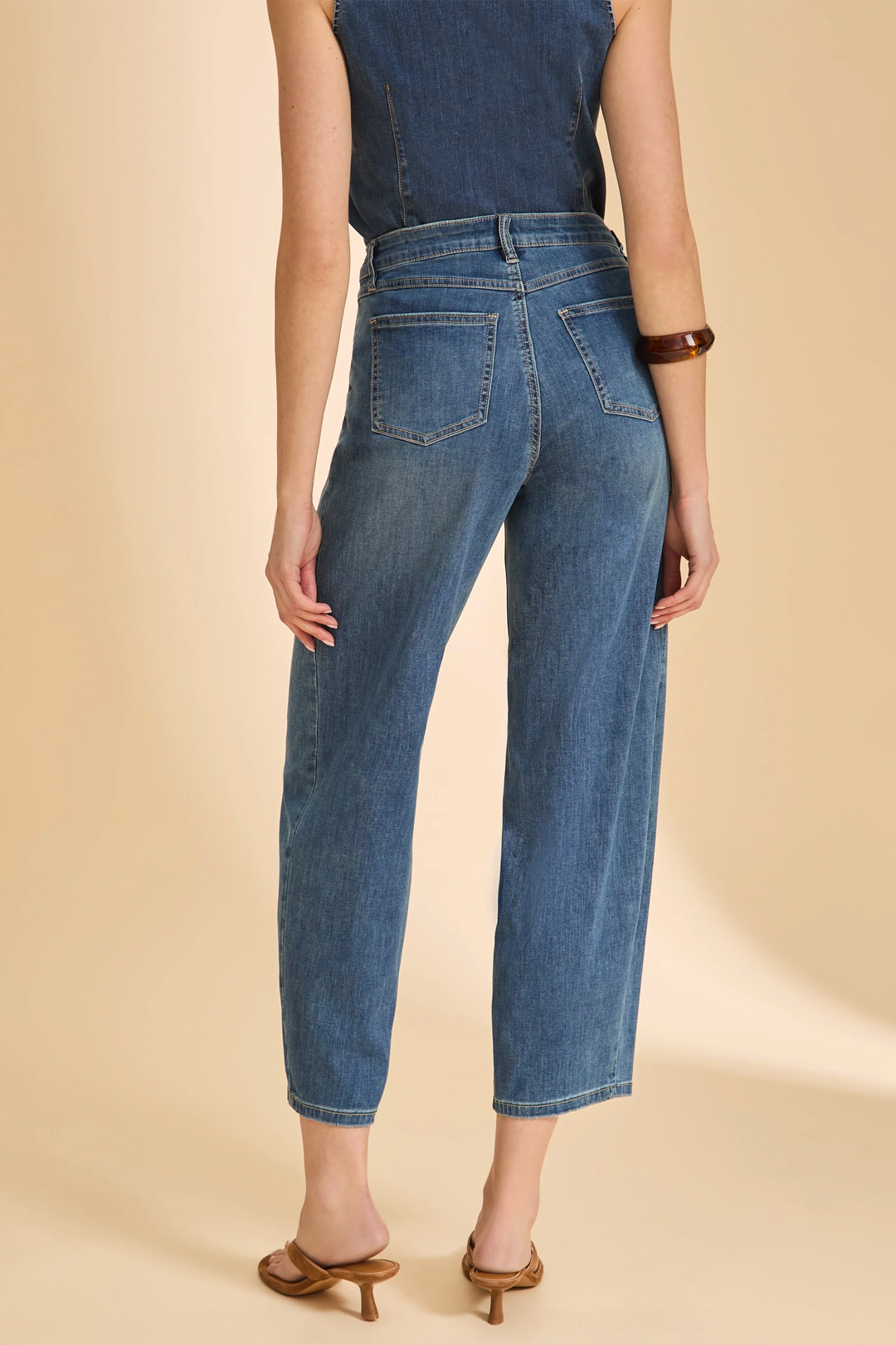 Person wearing blue jeans on a beige background