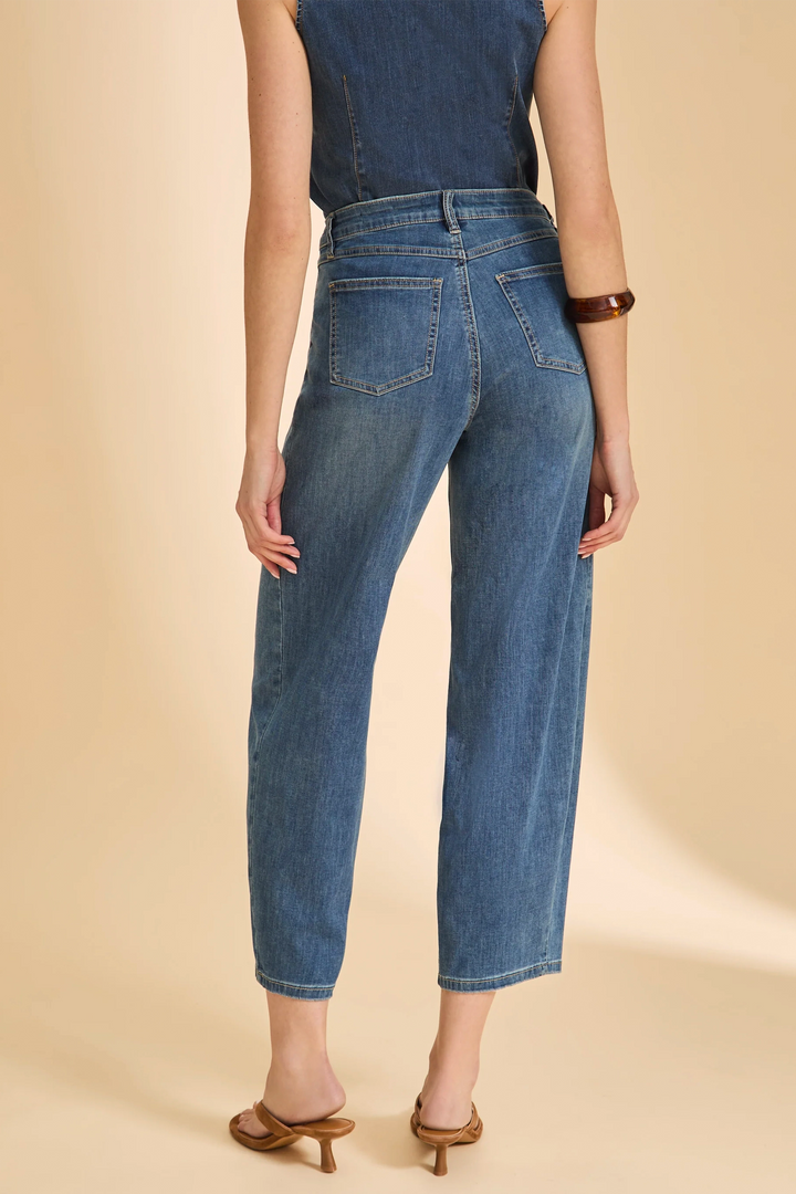 Person wearing blue jeans on a beige background