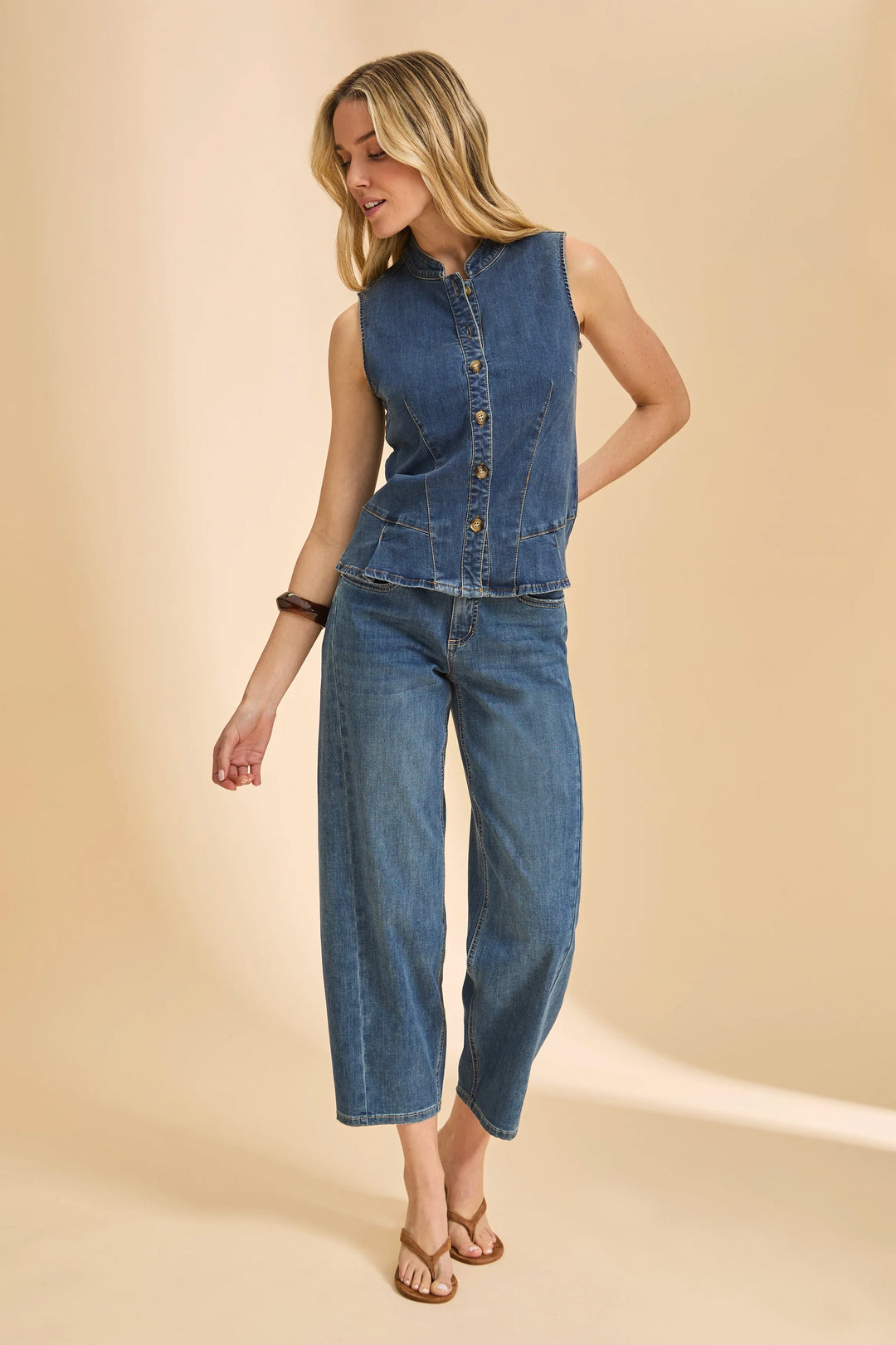 Woman wearing a denim outfit on a beige background