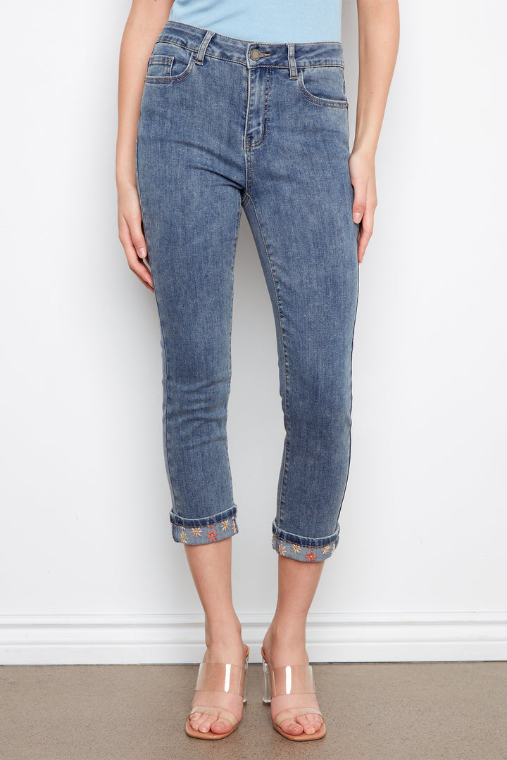 Person wearing blue jeans with a white wall background