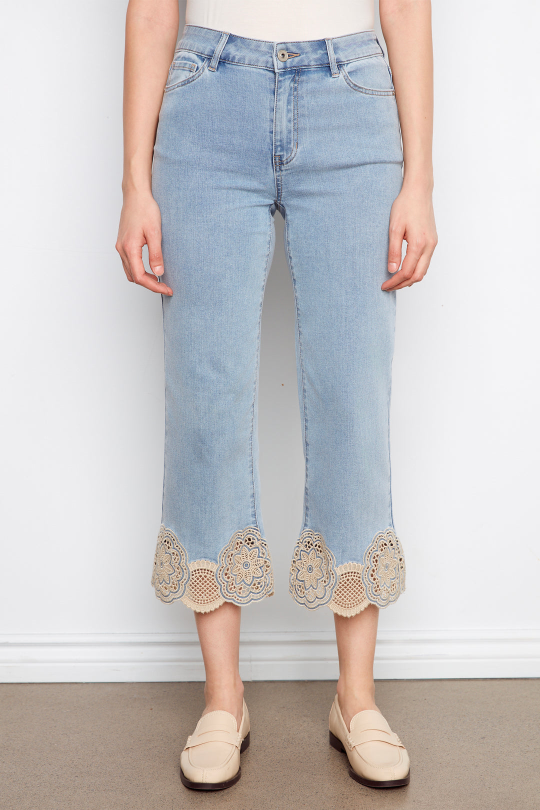 Light blue jeans with lace trim worn by a person on a plain background