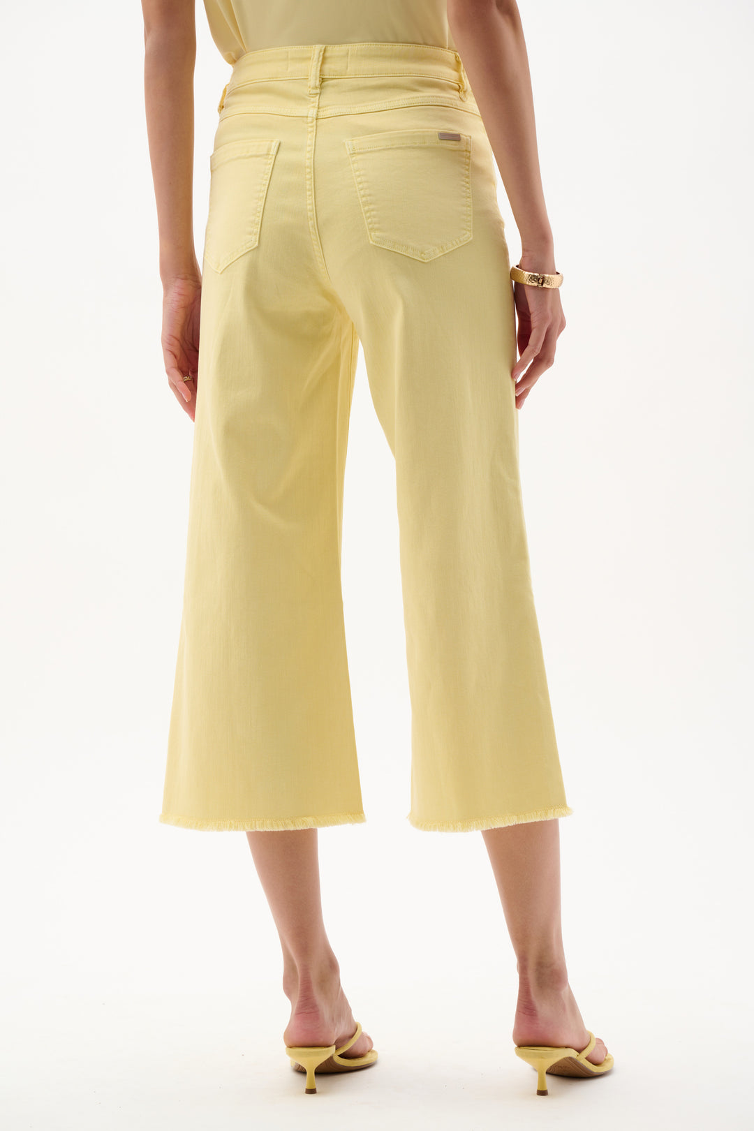 Person wearing light yellow pants on a white background