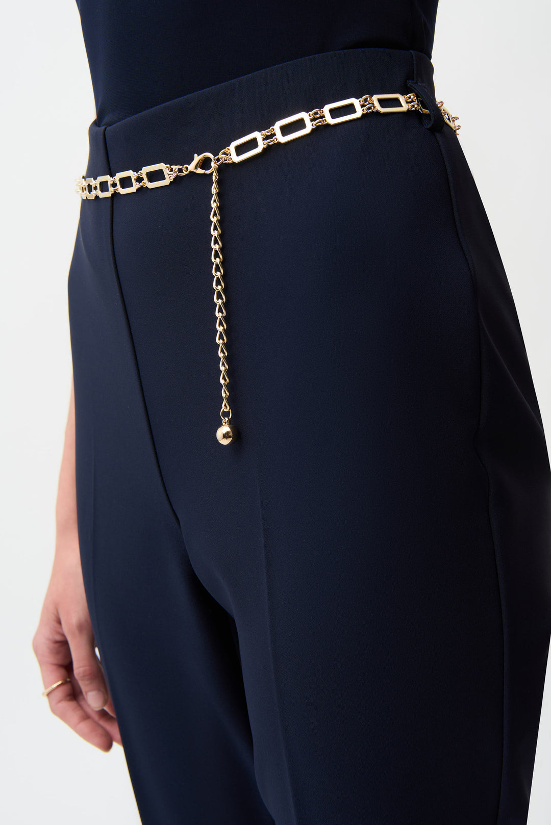 Navy blue pants with a gold chain belt on a white background