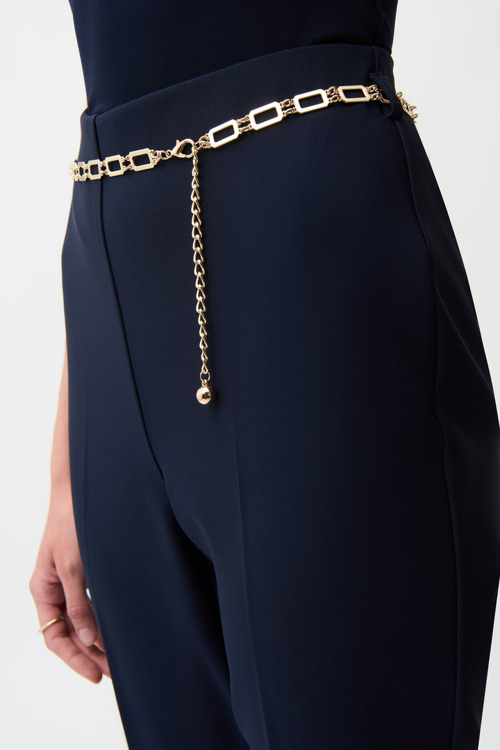 Navy blue pants with a gold chain belt on a white background