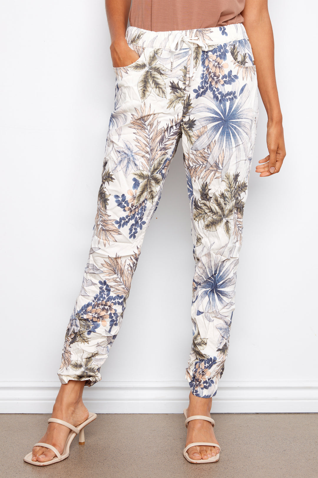 Person wearing floral print pants against a white background