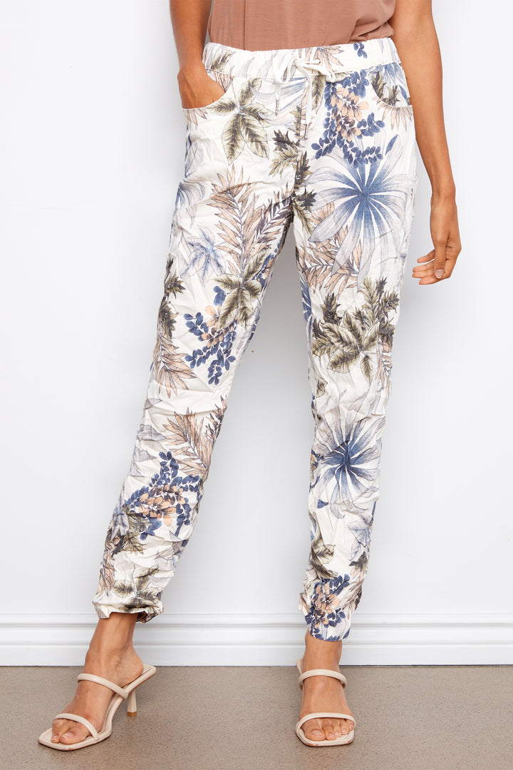 Person wearing floral print pants against a white background