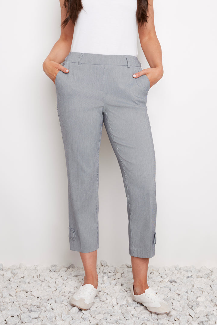 Person wearing gray crop pants standing on a white background