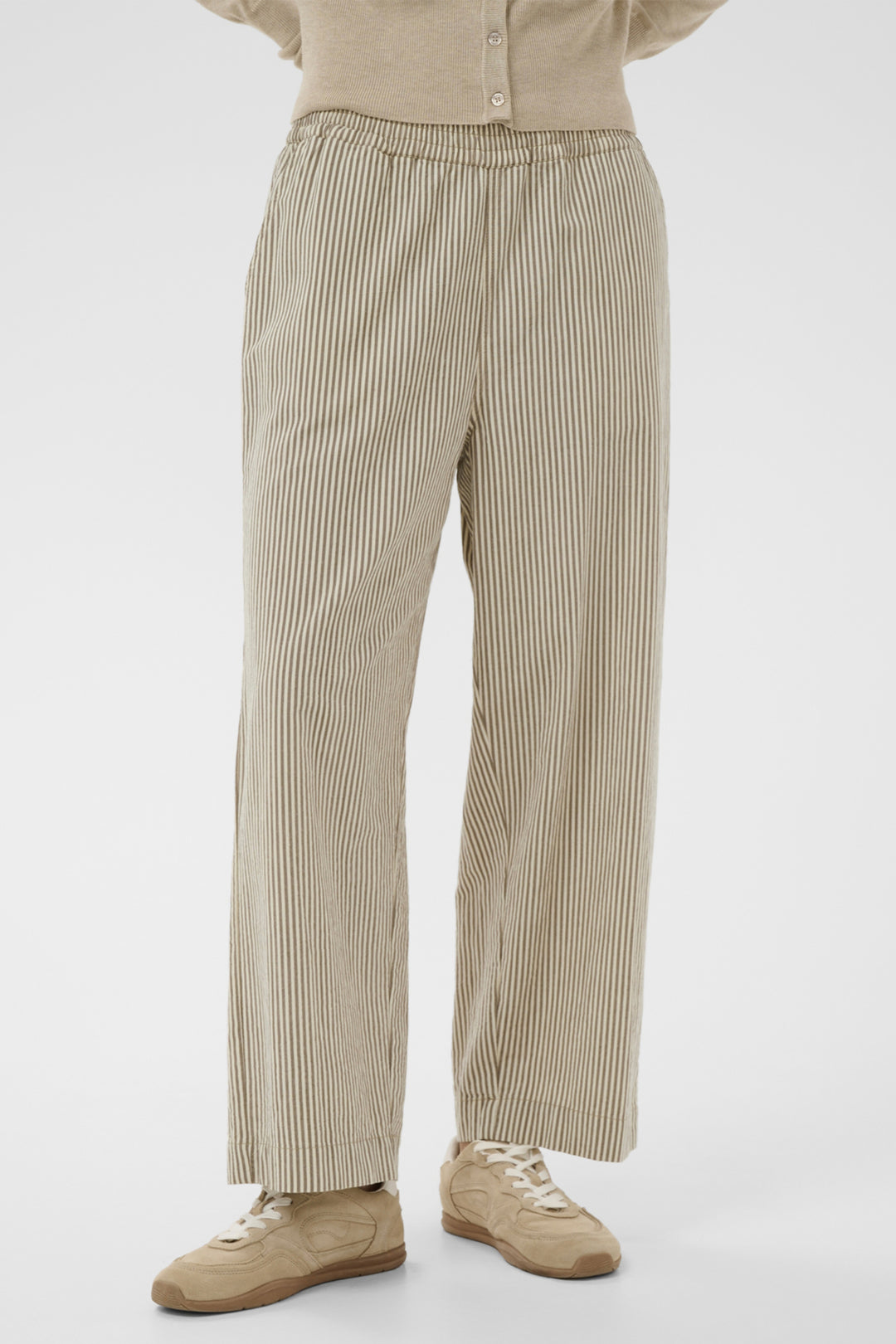 Person wearing beige striped wide-leg pants and a matching shirt on a white background