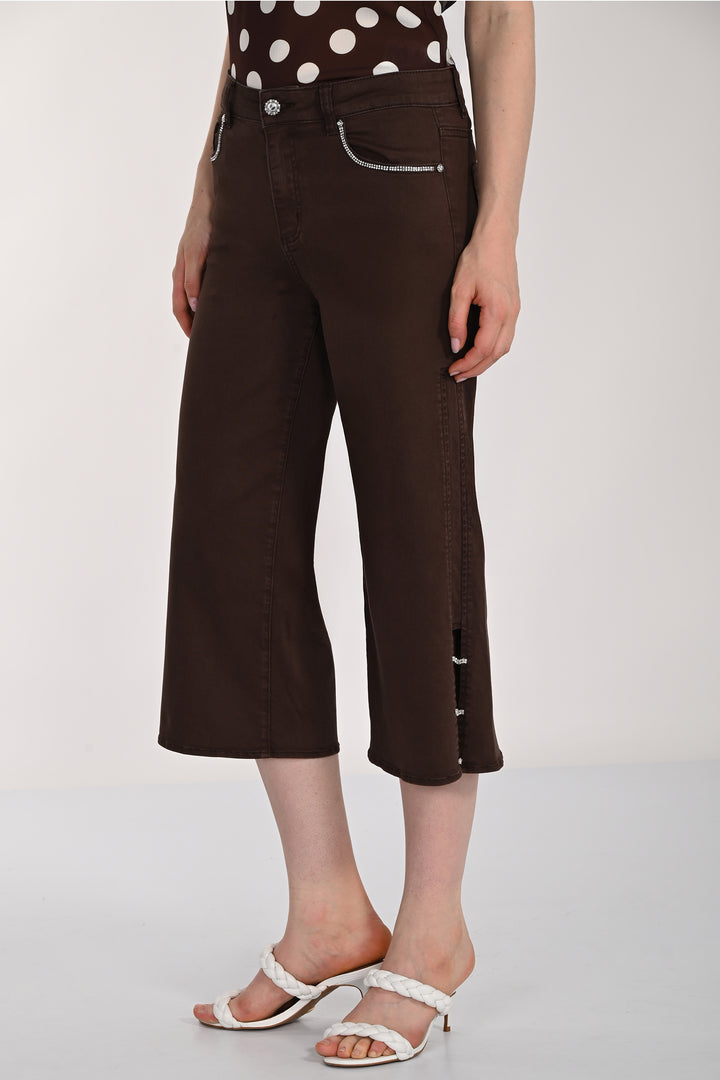 Brown wide-leg cropped jeans worn by a person on a plain background