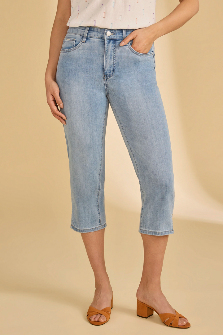 Person wearing light blue jeans on a beige background
