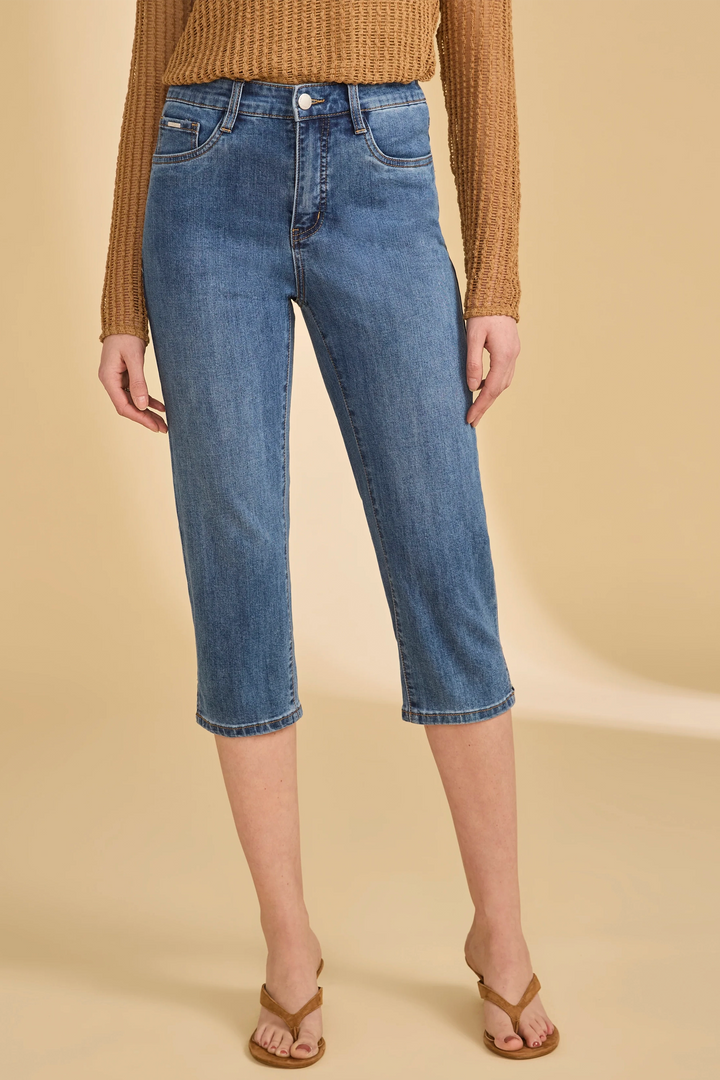 Person wearing blue jeans and a brown sweater on a beige background