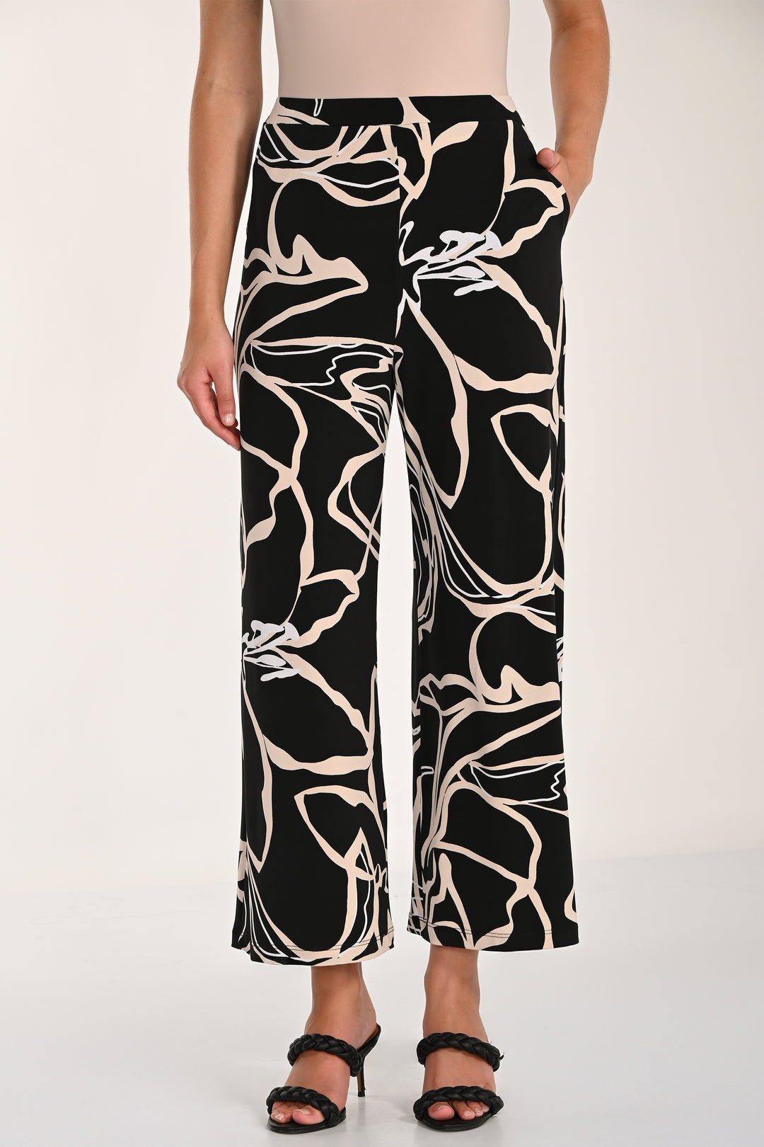 Black and white floral patterned wide-leg pants worn by a person on a white background