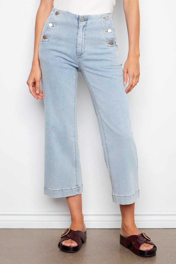 Light blue crop jeans worn by a person on a white background