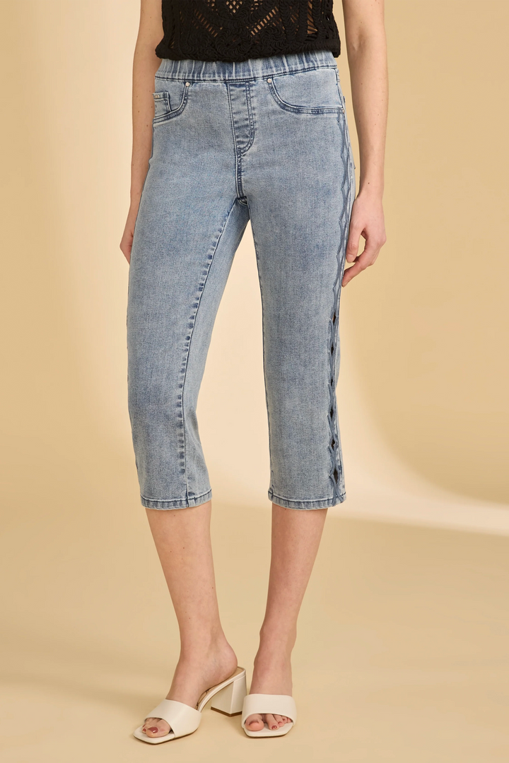 Person wearing light blue denim capri pull-on pants on a beige background