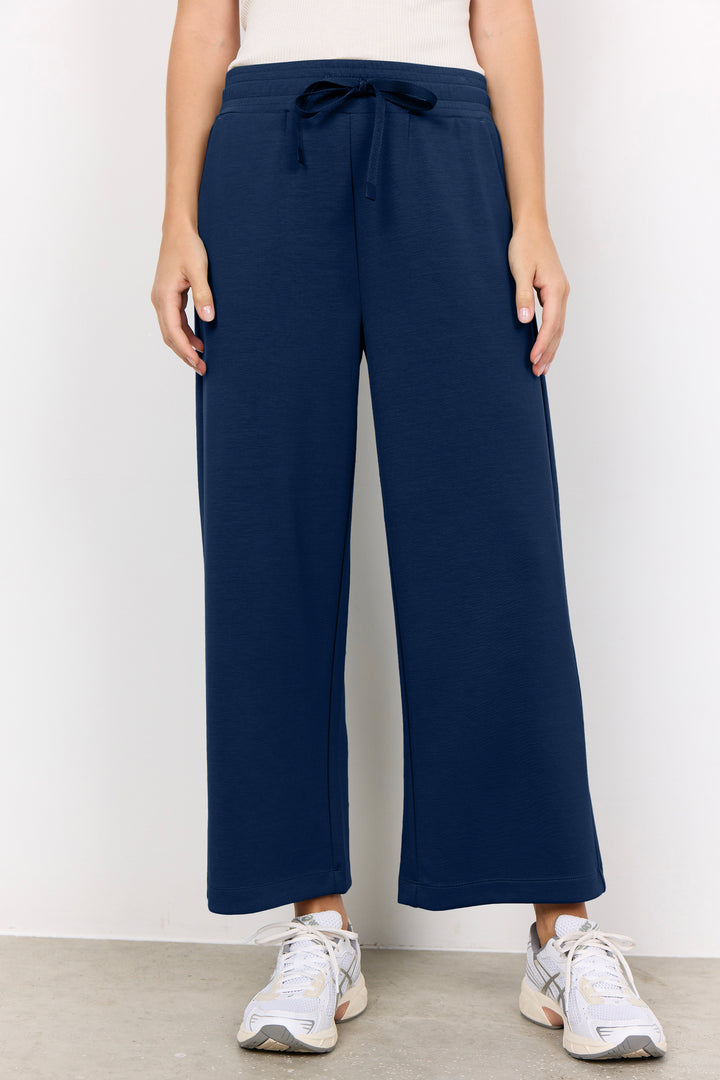 Navy blue jogger pants with drawstring worn by a person on a white background