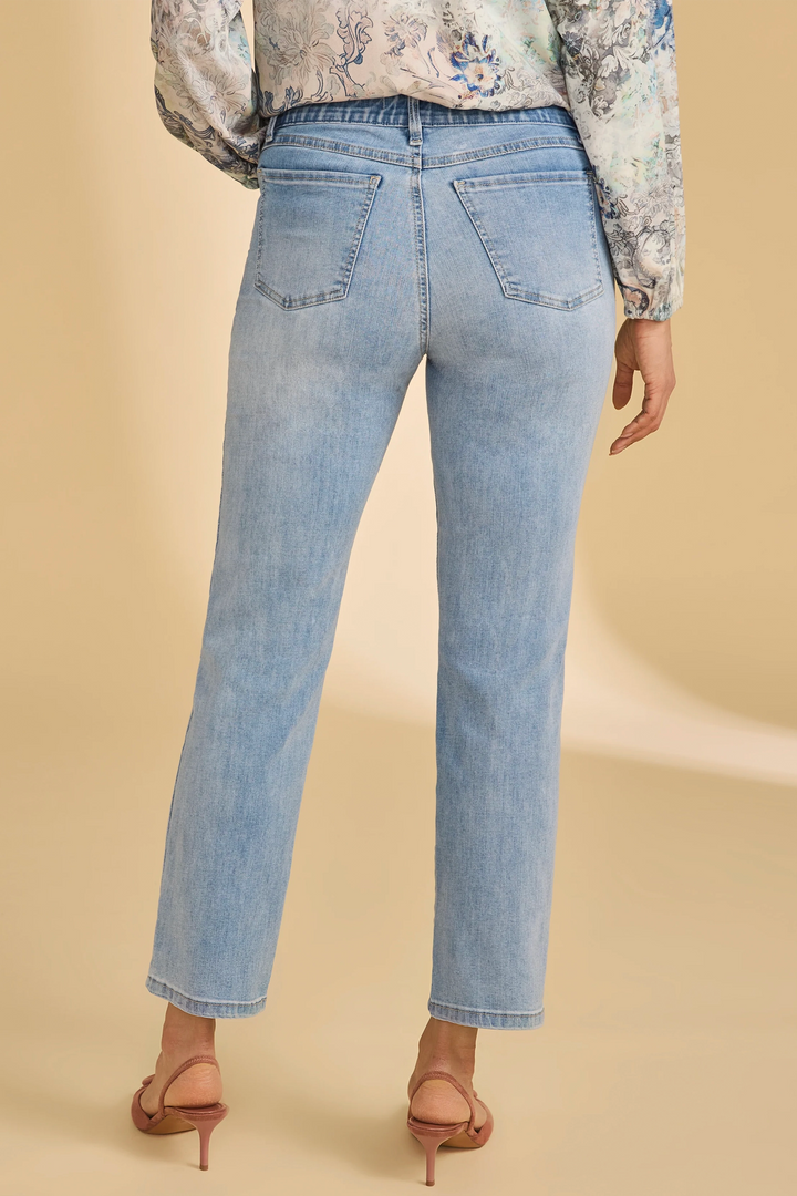 Light blue jeans worn by a person on a beige background