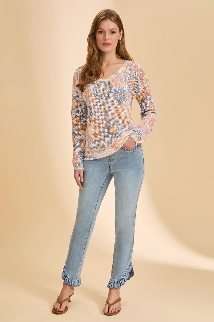 Woman wearing a patterned blouse and jeans on a beige background