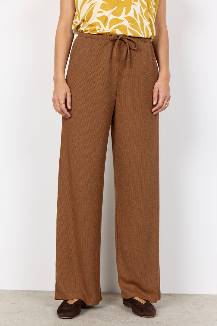 woman wearing light brown pants with a drawstring waist on a white background