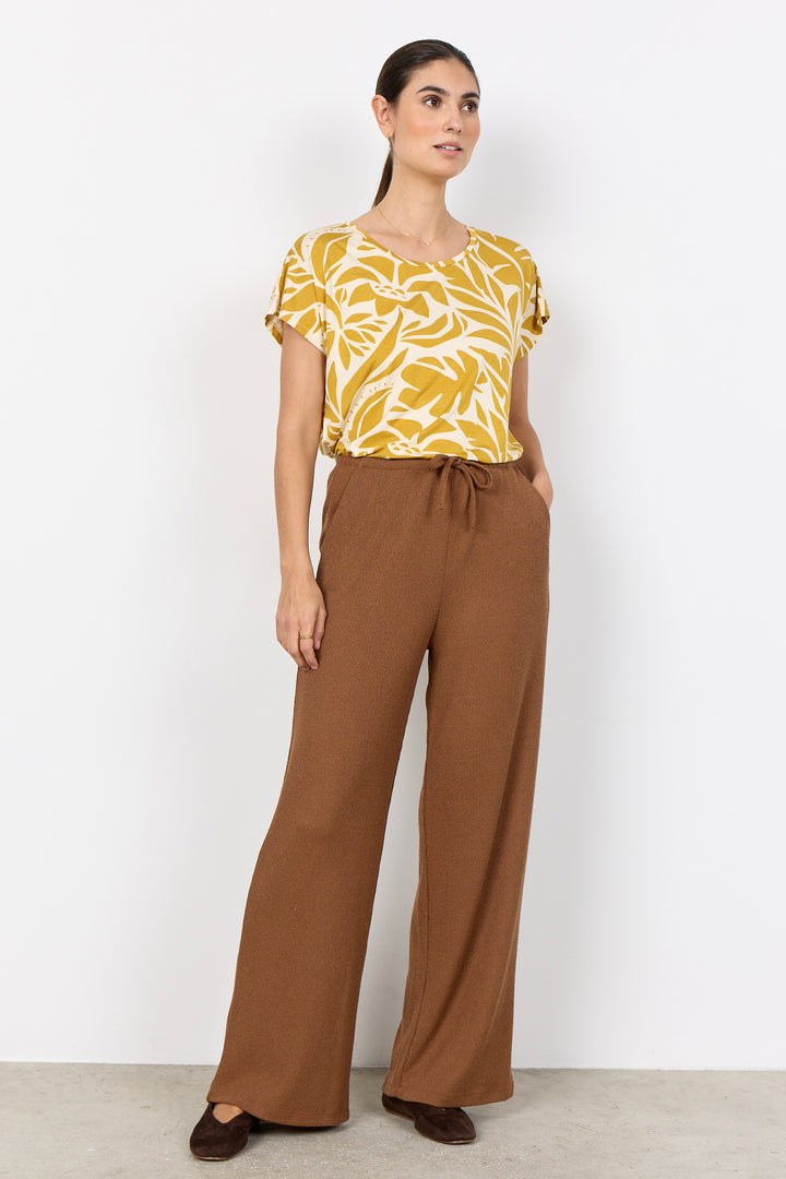 woman wearing light brown pants with a drawstring waist on a white background
