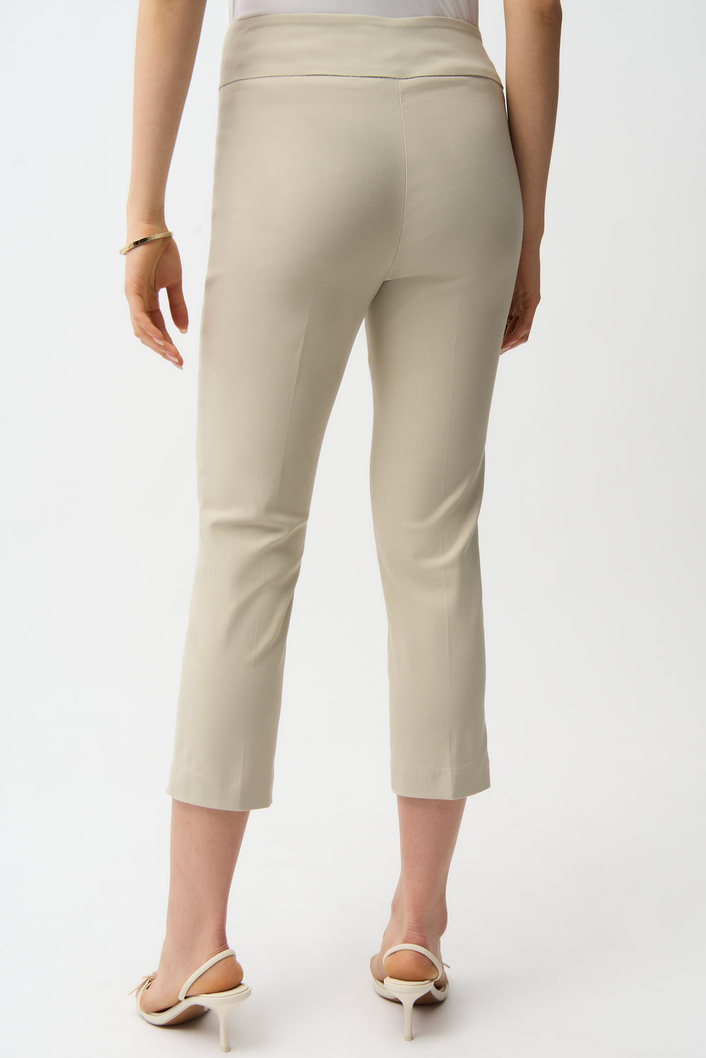 Beige pants worn by a person on a white background
