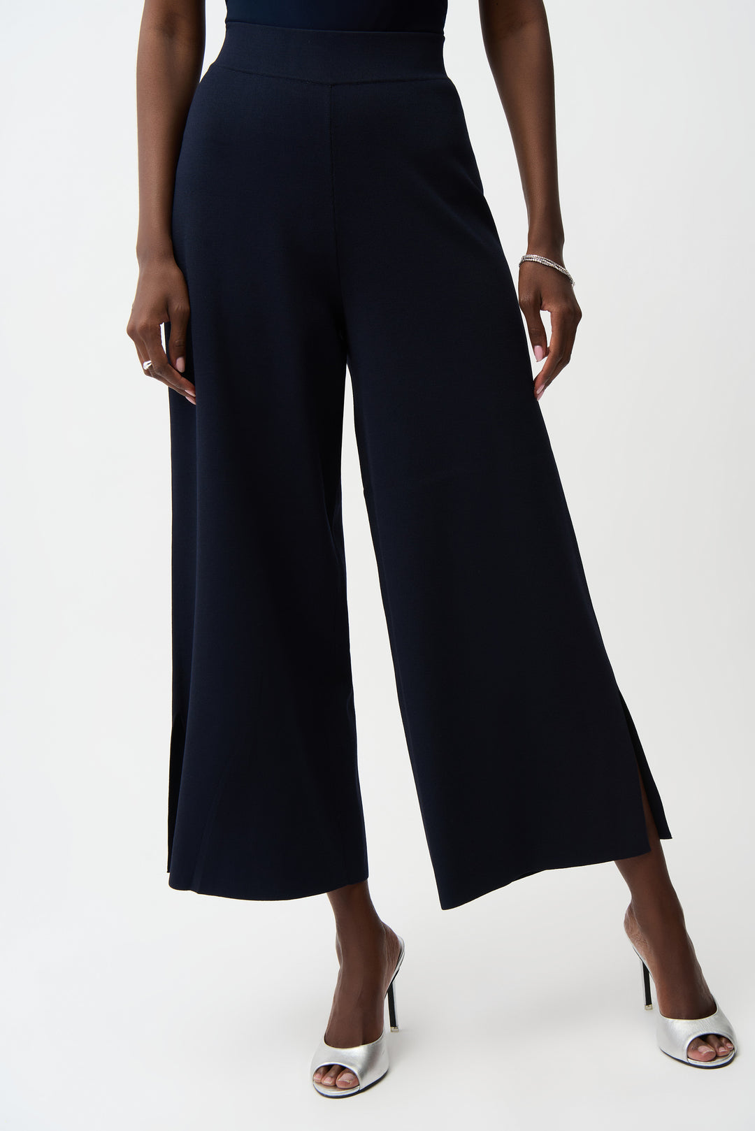 Person wearing navy blue wide-leg pants on a white background