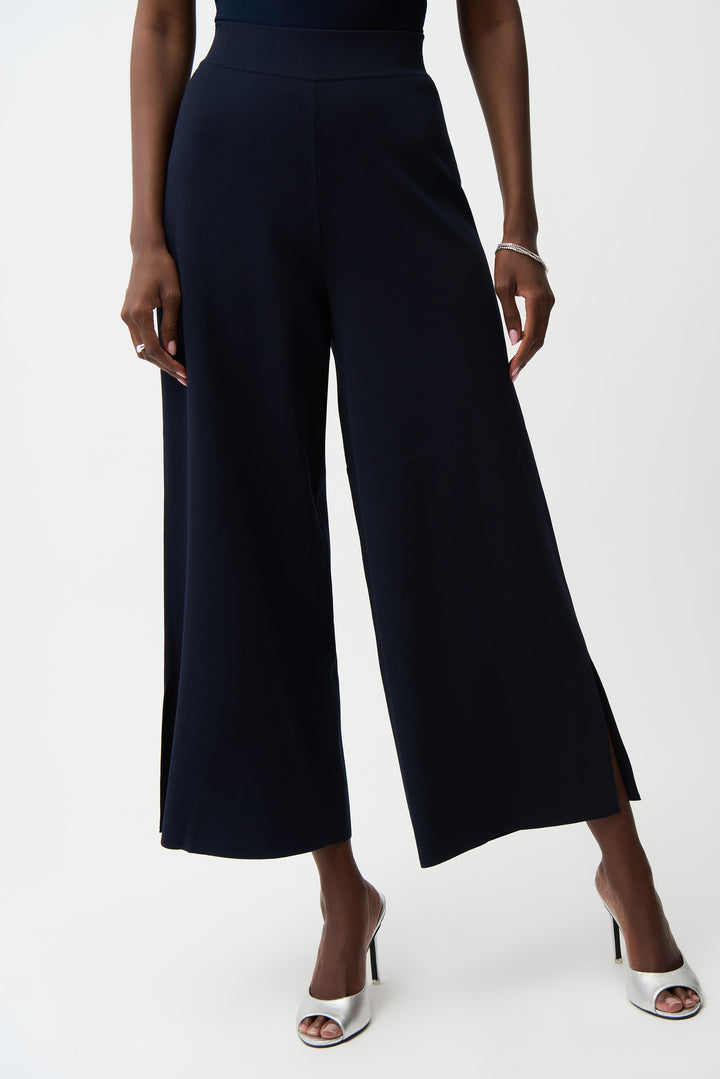 Person wearing navy blue wide-leg pants on a white background