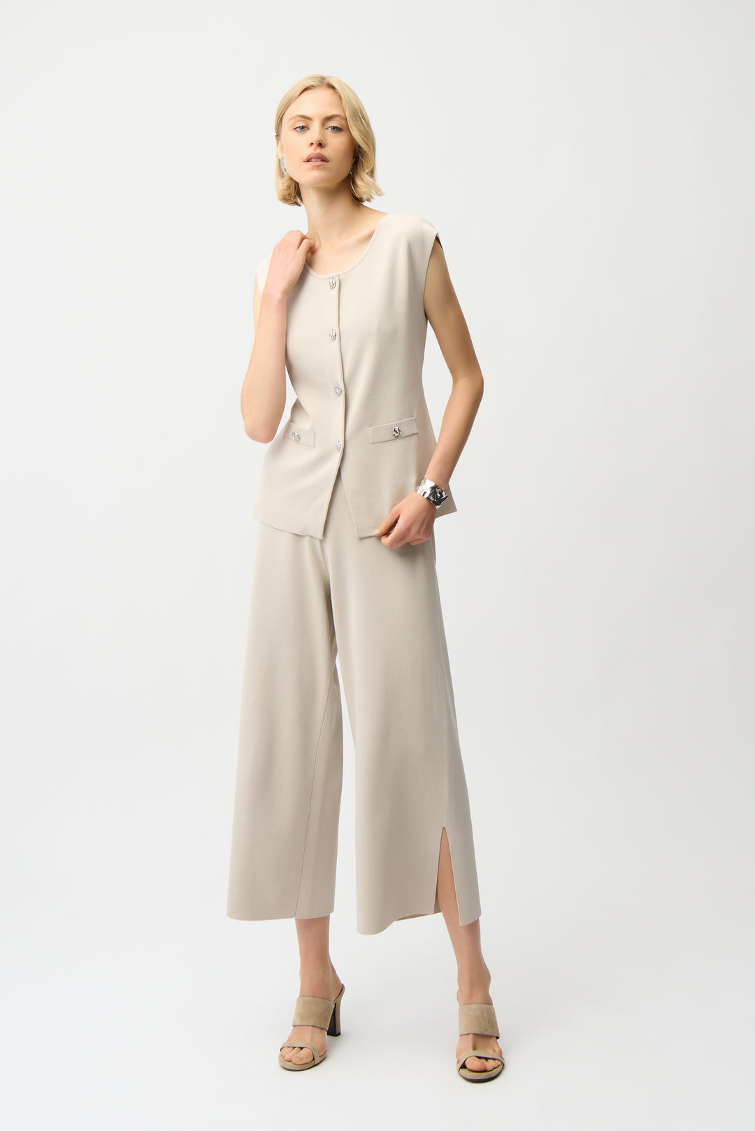 Woman wearing a beige sleeveless matching set on a white background