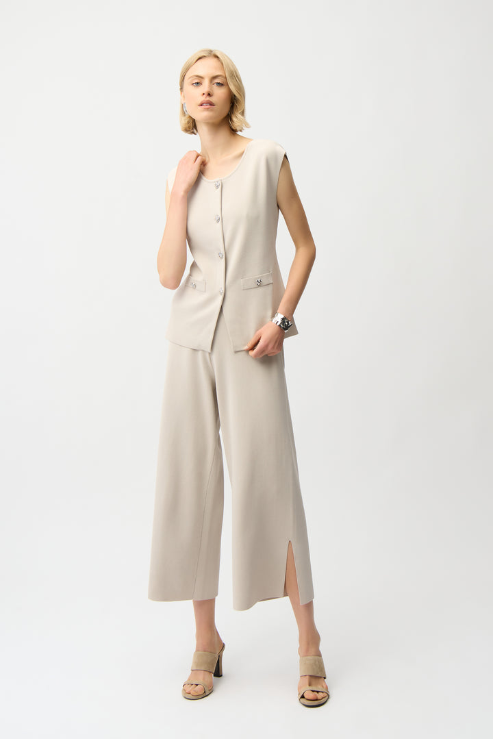 Woman wearing a beige sleeveless matching set on a white background
