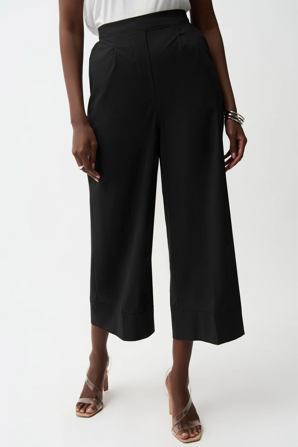 Person wearing black wide-leg pants on a white background