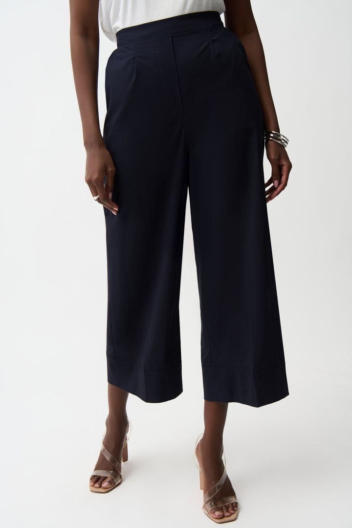 Person wearing navy blue wide-leg pants on a white background