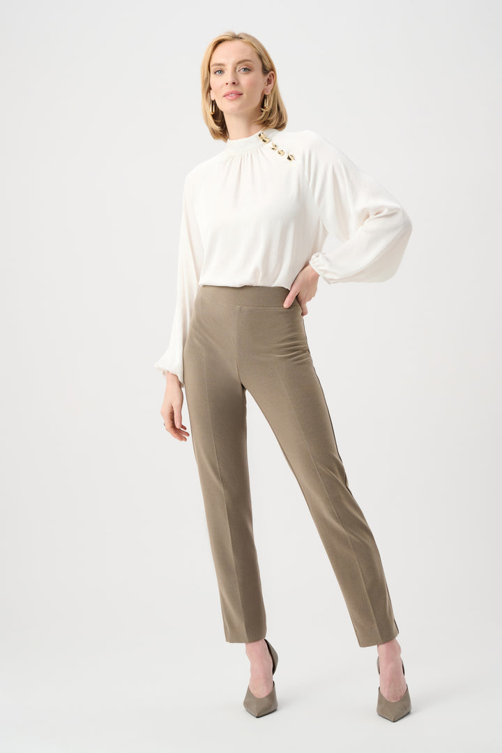 Woman wearing a white blouse and beige pants on a white background