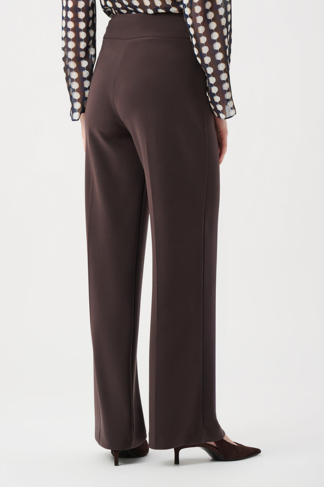 Brown wide-leg pants worn with a polka dot blouse on a white background