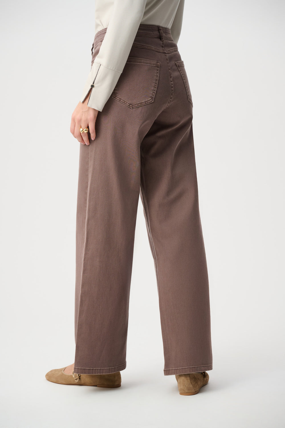 Person wearing brown wide-leg pants on a white background