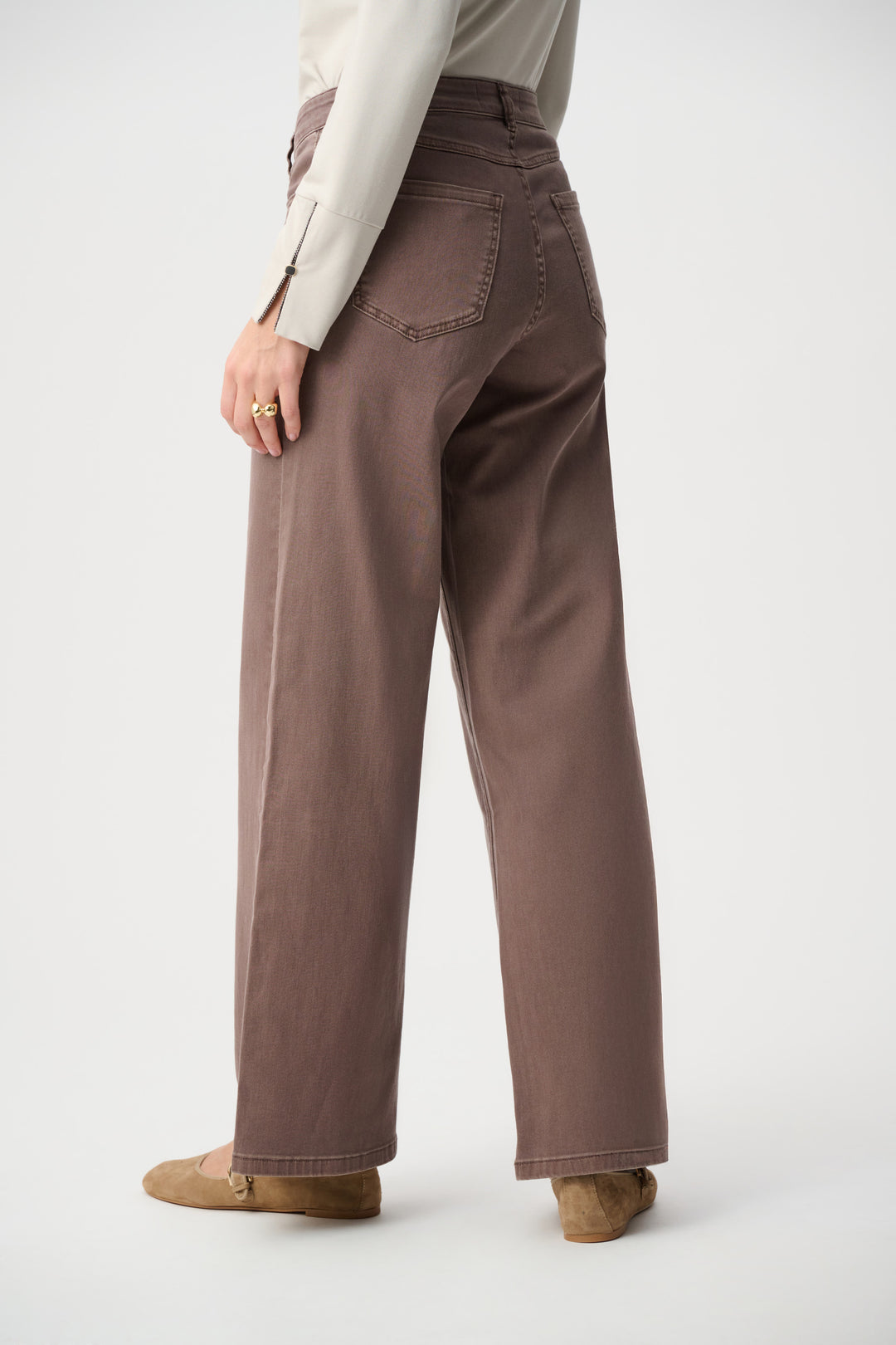 Person wearing brown wide-leg pants on a white background