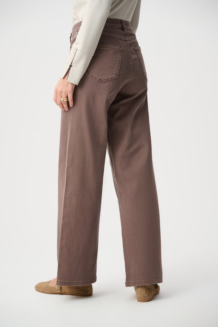 Person wearing brown wide-leg pants on a white background