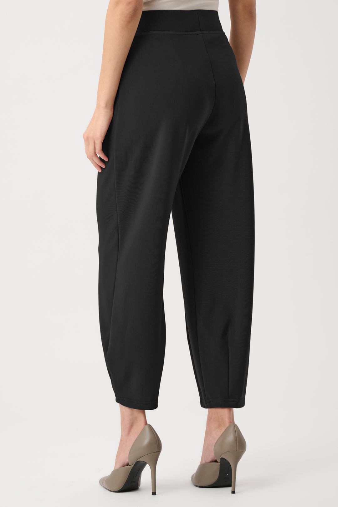 Black pants worn by a person on a white background