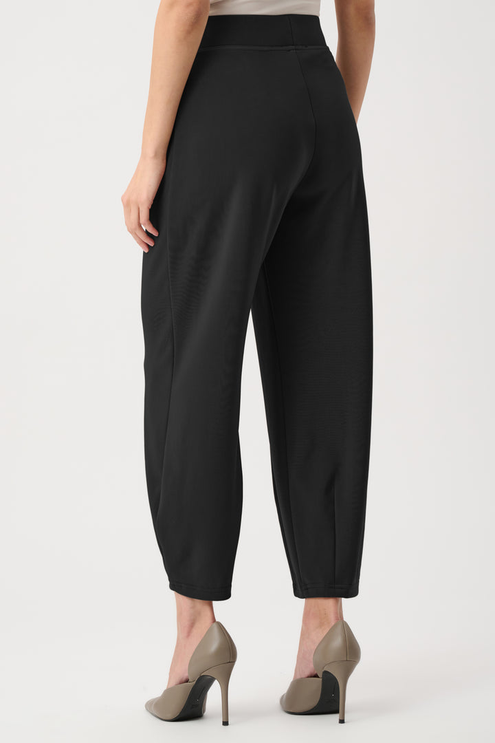 Black pants worn by a person on a white background