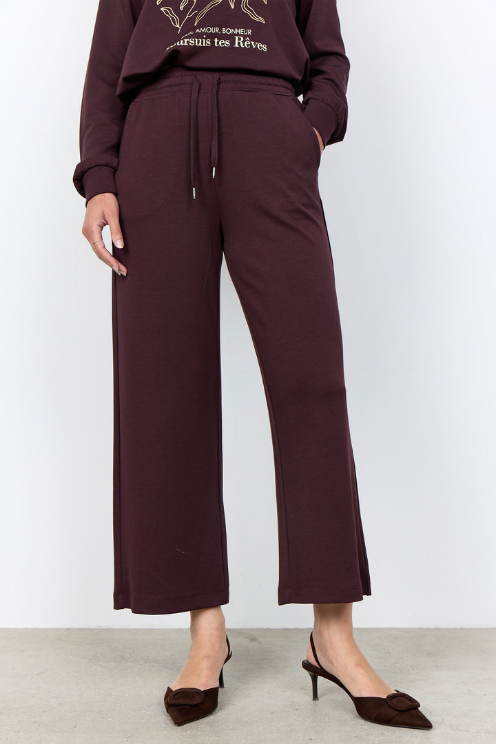 woman wearing casual straight leg sweatpants and matching sweater on a white background. 