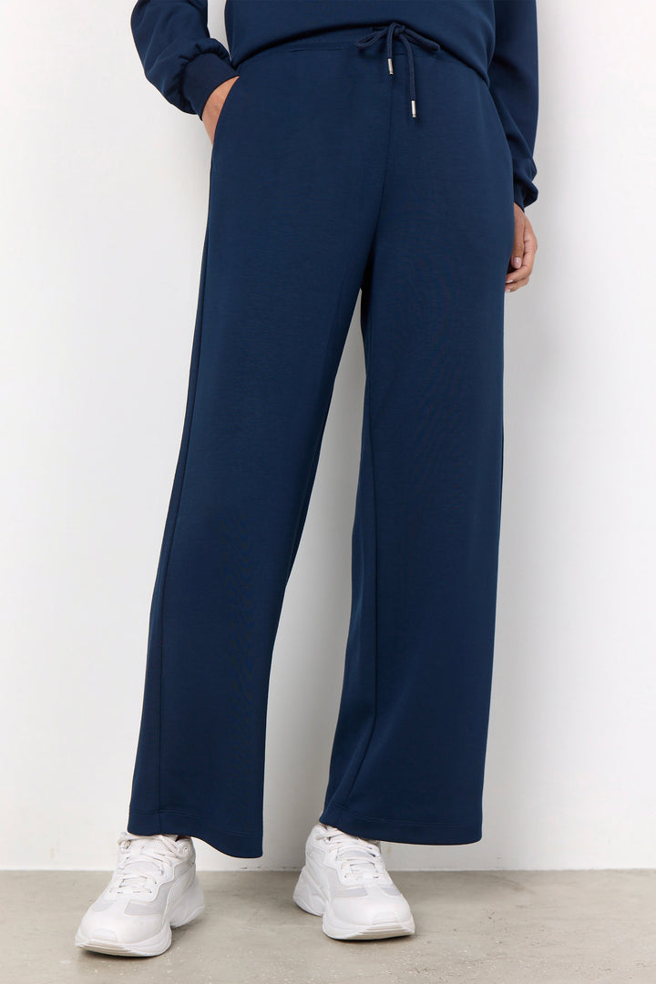 woman wearing casual straight leg sweatpants and matching sweater on a white background. 