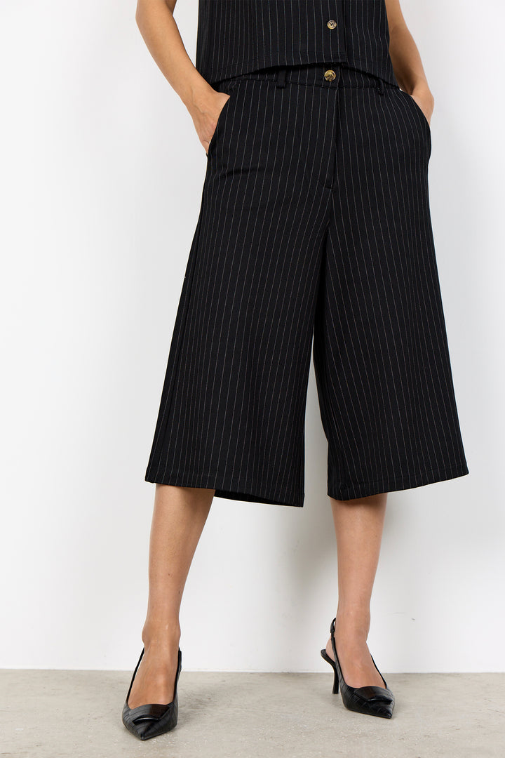 woman wearing wide leg pinstripe culottes and matching vest on a white background. 