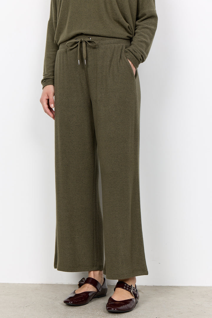 woman wearing casual sweatpants and matching top on a  white background. 