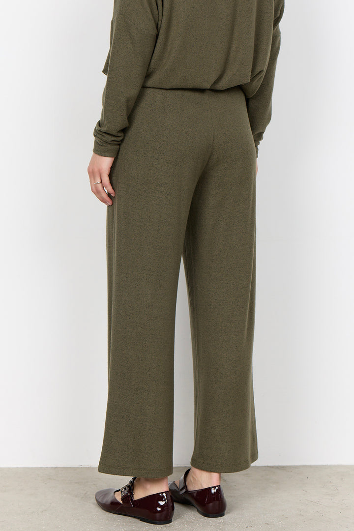 woman wearing casual sweatpants and matching top on a  white background. 