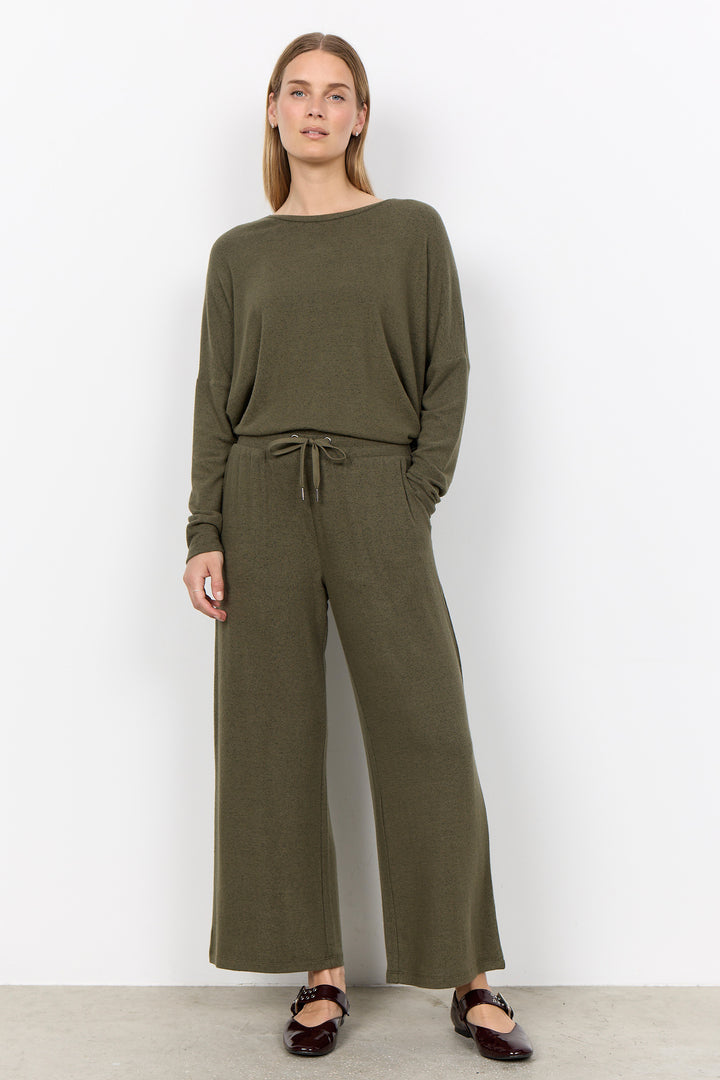 woman wearing casual sweatpants and matching top on a  white background. 