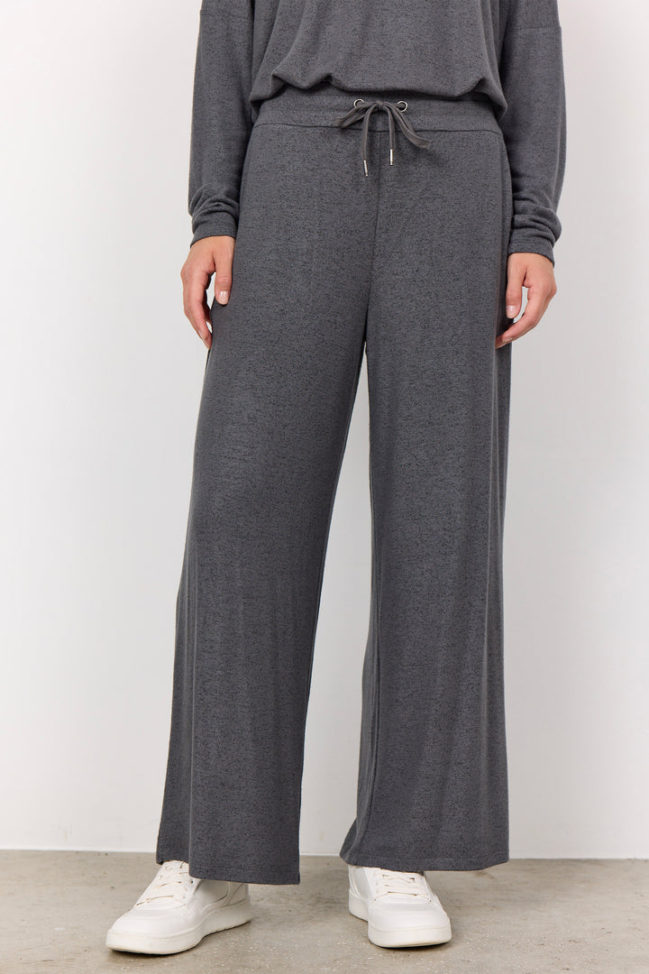 woman wearing casual sweatpants and matching top on a  white background. 