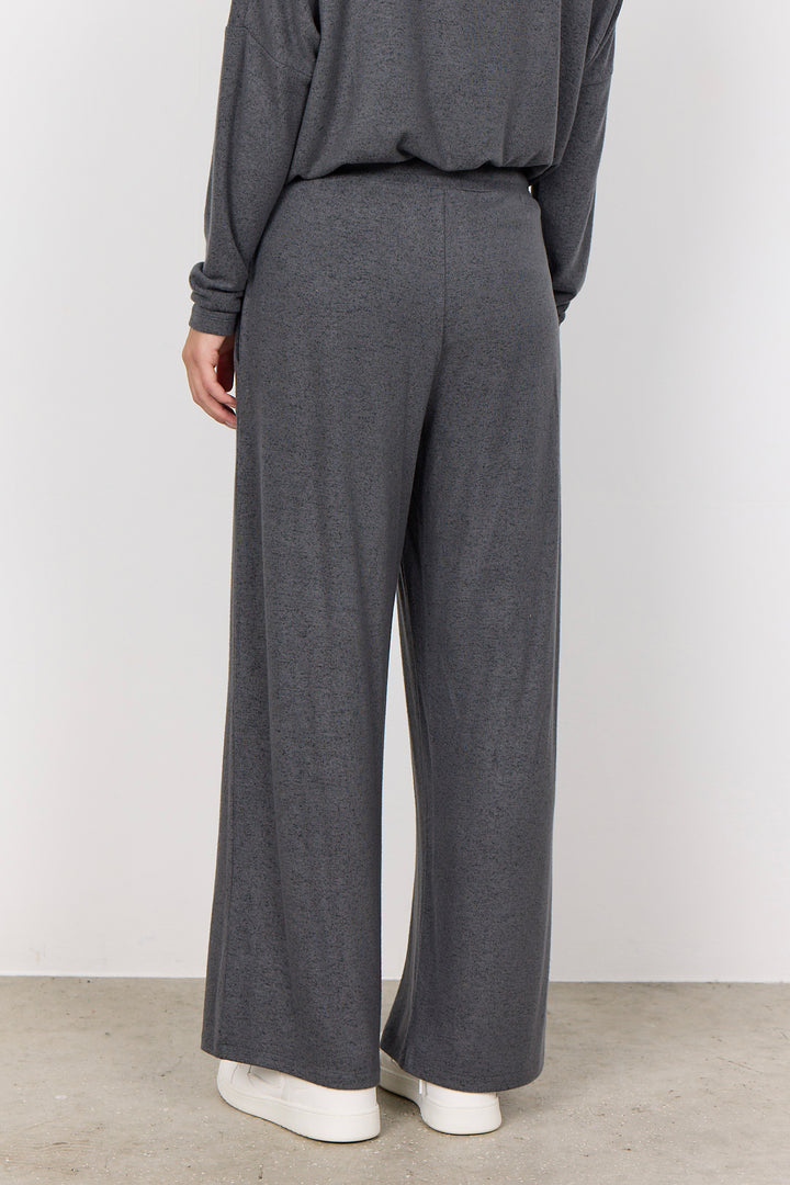 woman wearing casual sweatpants and matching top on a  white background. 