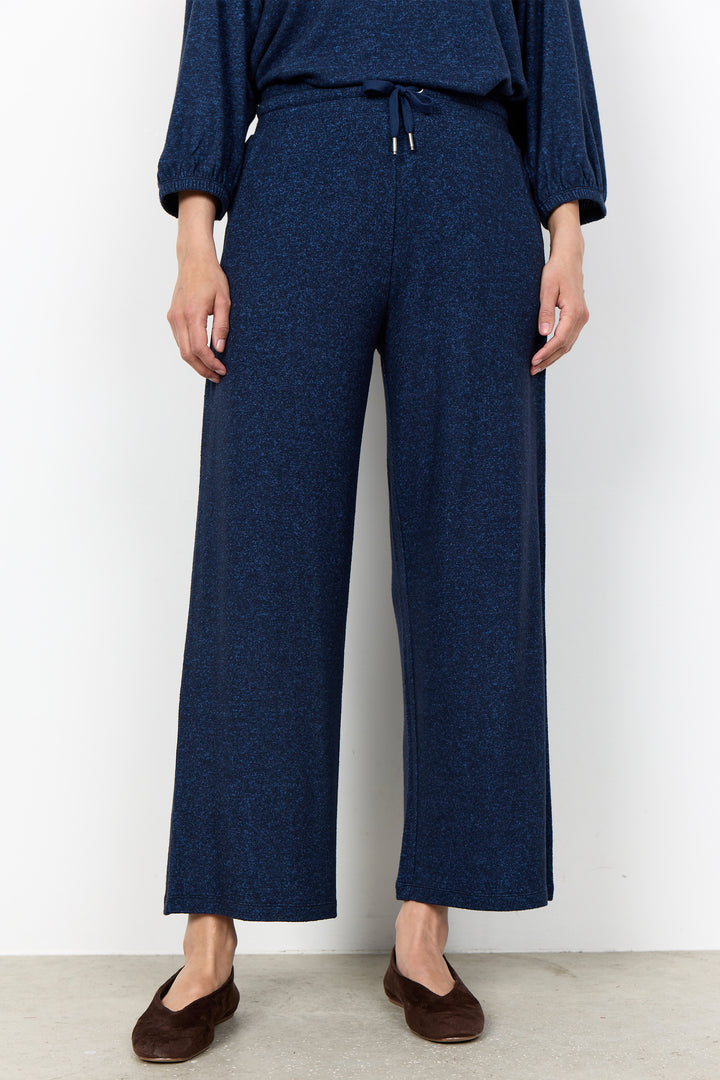 woman wearing casual sweatpants and matching top on a  white background. 