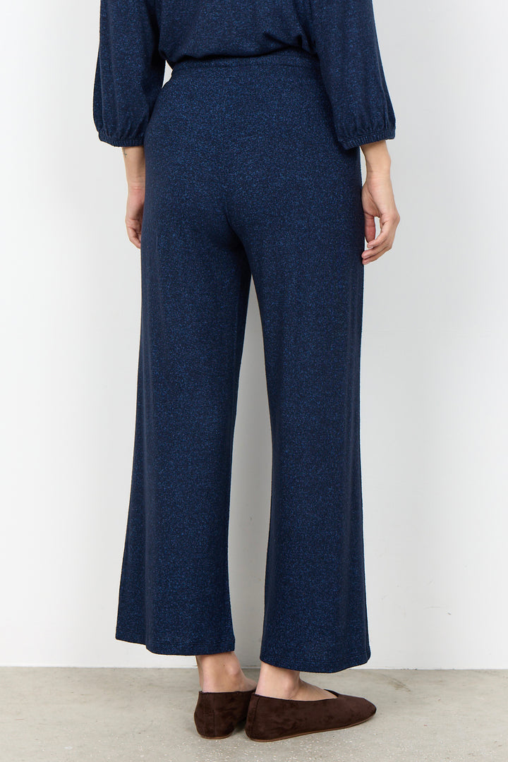 woman wearing casual sweatpants and matching top on a  white background. 