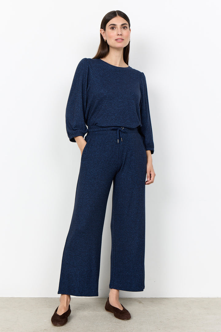 woman wearing casual sweatpants and matching top on a  white background. 