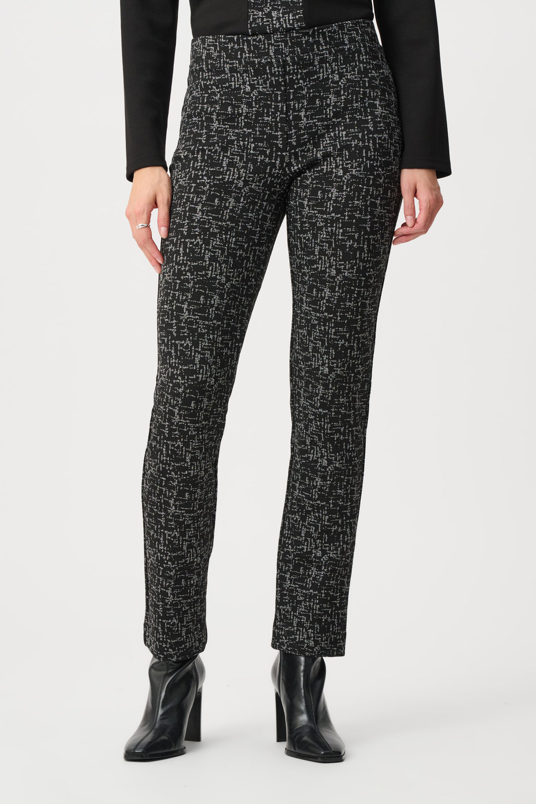 Person wearing black and white patterned pants with a plain background