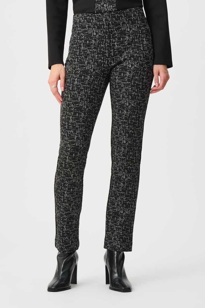 Person wearing black and white patterned pants with a plain background